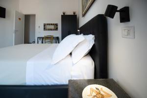 a bedroom with a bed with white sheets and pillows at Catania Over Time - Tourist Rooms in Catania