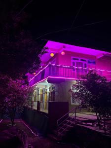 een huis verlicht met paarse lichten bij Tirthan Living Green Home Stays in Banjār