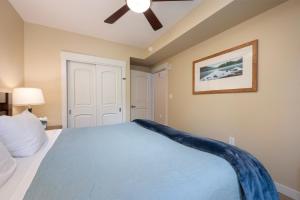 a bedroom with a blue bed with a ceiling fan at Fraser Crossing 3227 Ski In Ski Out Winter Park Resort in Winter Park