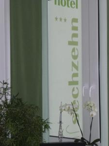 レバークーゼンにあるホテルセシュツェーンの看板の横の花瓶