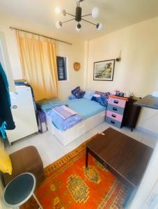 ein kleines Schlafzimmer mit einem Bett und einem Tisch in der Unterkunft Taghazout studio & rooftop in Taghazout