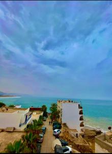 ein Strand mit am Meer geparkten Autos in der Unterkunft Taghazout studio & rooftop in Taghazout