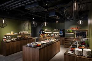 a restaurant with a buffet line with food at ARCOTEL AQ Wien in Vienna