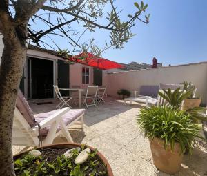 サン・マルタン・ド・レにあるAppartement VAUBAN proche plageの家の上の椅子とテーブルのあるパティオ +6枚の写真