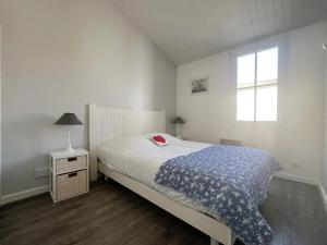 サン・マルタン・ド・レにあるAppartement VAUBAN proche plageのベッドと窓のある白い寝室