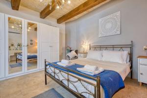 a bedroom with a bed with towels on it at Gudja 2BR - A Home of Character in the Village Core in Gudja