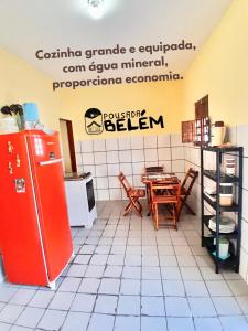 eine Küche mit einem roten Kühlschrank und einem Tisch in der Unterkunft Casa em Campina Grande, Bairro tranquilo, Próximo ao centro, 2 Quartos, Garagem in Campina Grande