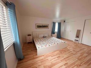 una camera con letto bianco e pavimento in legno di Coral Castaway-Block from Ocean Casino & Waterpark ad Atlantic City