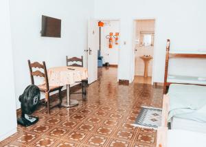 a living room with a table and chairs and a table at Pousada Praia do Sonho in Itanhaém