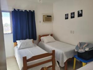 Zimmer mit 2 Betten und einem blauen Vorhang in der Unterkunft Rê apdetemporadas em Olímpia 53 o melhor para sua Família Faça ja sua reserva in Olímpia + 64 Fotos