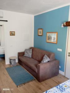 un soggiorno con divano marrone e parete blu di villa Cretaccio Arco,bilocale in casa di campagna a 5 Min dal lago con deposito bici e attrezzatura ad Arco