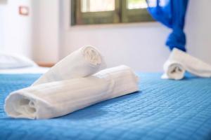 a pair of wrapped up towels on a bed at JERA Holiday Collection VULCANO UNO - Garden View in Vulcano +18 photos