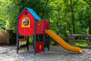Un pequeño parque infantil con un tobogán y un tobogán. en Camping Le Barutel, en Meyras
