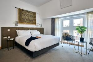 a hotel room with a bed and a large window at Líbere London Edgware Road in London