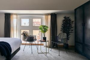 a bedroom with a bed and chairs and a window at Líbere London Edgware Road in London