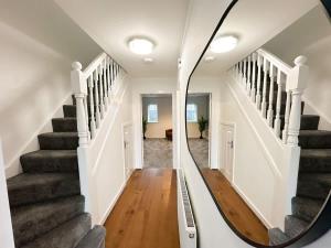 Un espejo que refleja un pasillo con escaleras en una casa. en Densham House by Blue Skies Stays, en Stockton-on-Tees