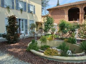 a garden in front of a house with a building at Lacetoliera Residenza d'epoca in Bosco Marengo