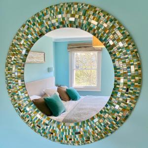 a mirror in a room with a bed and a window at The Art House Hove in Brighton & Hove