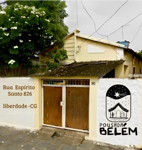 ein Gebäude mit zwei Türen und einem Schild darauf in der Unterkunft Casa em Campina Grande, Bairro tranquilo, Próximo ao centro, 2 Quartos, Garagem in Campina Grande