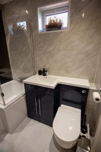 une salle de bain avec des toilettes blanches et un lavabo dans l'établissement Hilltop Apartments, à Salisbury