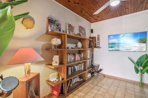 圣吕斯Villa H'Om Zen的客厅设有书架,书架上摆放着书籍