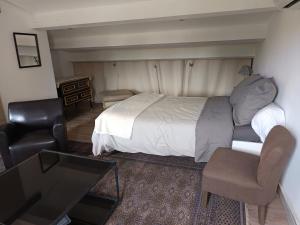 a bedroom with a bed and a desk and a television at chambre independante in Balaruc-les-Bains