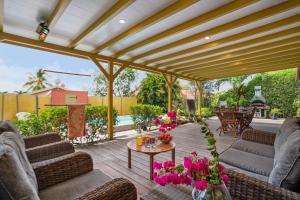 圣吕斯Villa H'Om Zen的天井配有沙发和鲜花桌