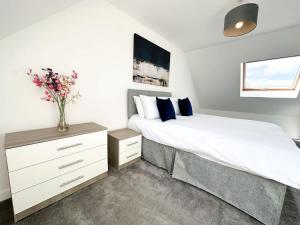 a bedroom with a bed and a vase with flowers on it at Chestnut House by Blue Skies Stays in Middlesbrough