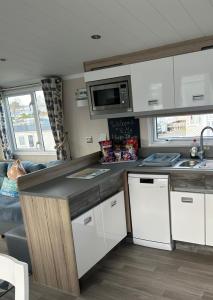 a kitchen with white cabinets and a counter top at The Lighthouse Caravan in Wyke Regis
