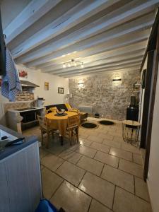 a dining room with a table and a stone wall at Butterfly Cottage in Pouilly-sur-Loire