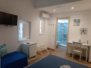 a living room with a blue couch and a desk at Oltremare in Cefalù