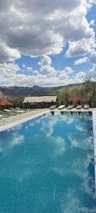 a large swimming pool with blue water in a house at Soare-n Maramureș in Budeşti