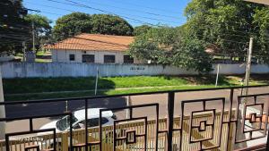 a view of a house from a balcony with a fence at Quarto individual solteiro in Campo Grande