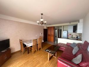 a living room with a red couch and a table at Apartment Sea Point in Bečići
