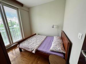Un dormitorio pequeño con una cama y una ventana. en Apartment Sea Point, en Bečići