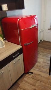 een rode koelkast in een keuken met een houten vloer bij Picturesque apartment into antique fortress in Daugavpils