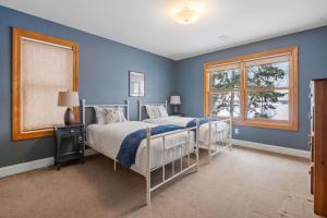 a blue bedroom with two beds and a window at Minnetonka Dream in Orono