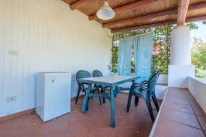 a blue table and chairs on a patio with a window at Jera suite vista mare 2 in Vulcano +19 photos