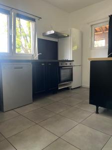 a kitchen with blue cabinets and a stove top oven at L'écrin du Bonheur in Saint-Bardoux