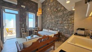 a living room with a couch and a stone wall at Efi's Apartments in Plaka Milou