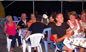 a group of people sitting at tables in a crowd at ZEcamping 3 étoiles animaux acceptés piscine chauffée restaurant et soirées in Huelgoat