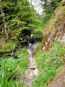 un homme faisant un vélo sur une piste cyclable dans l'établissement Camping 3 étoiles - Piscine - ccafbbc, à Huelgoat