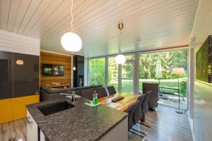 a kitchen and living room with a table and a couch at 4 Personen mit Sauna F1H5 in Ruhla +11 photos