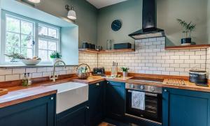 a kitchen with blue cabinets and a sink at The Retreat Tetbury - NEW listing in Tetbury