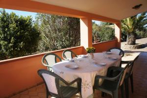 a table and chairs on a porch with a table and chairs at CalaSoul in SantʼAntìoco