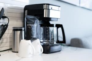 Una cafetera sobre un mostrador con dos tazas de café. en Sable 302 - Alcove, en Minneapolis