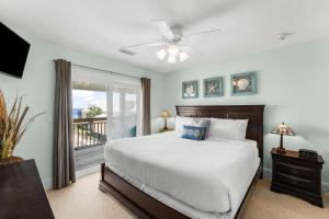 a bedroom with a bed and a balcony at Pet Friendly Beach House - One Palm by Panhandle Getaways in Port Saint Joe +41 photos