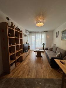 ein Wohnzimmer mit Sofa und Fernseher in der Unterkunft Apartament Wiatraczna in Warschau