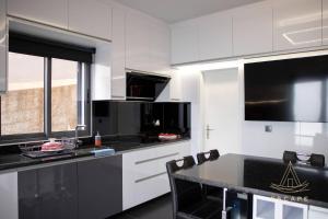 a kitchen with white cabinets and a black counter top at Villa Izilda by ESCAPE to Madeira in Ponta do Sol