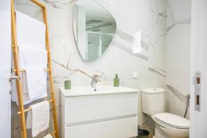 ein Badezimmer mit Waschbecken, Toilette und Spiegel in der Unterkunft Green House Beach Side Oasis in Vila Baleira + 24 Fotos